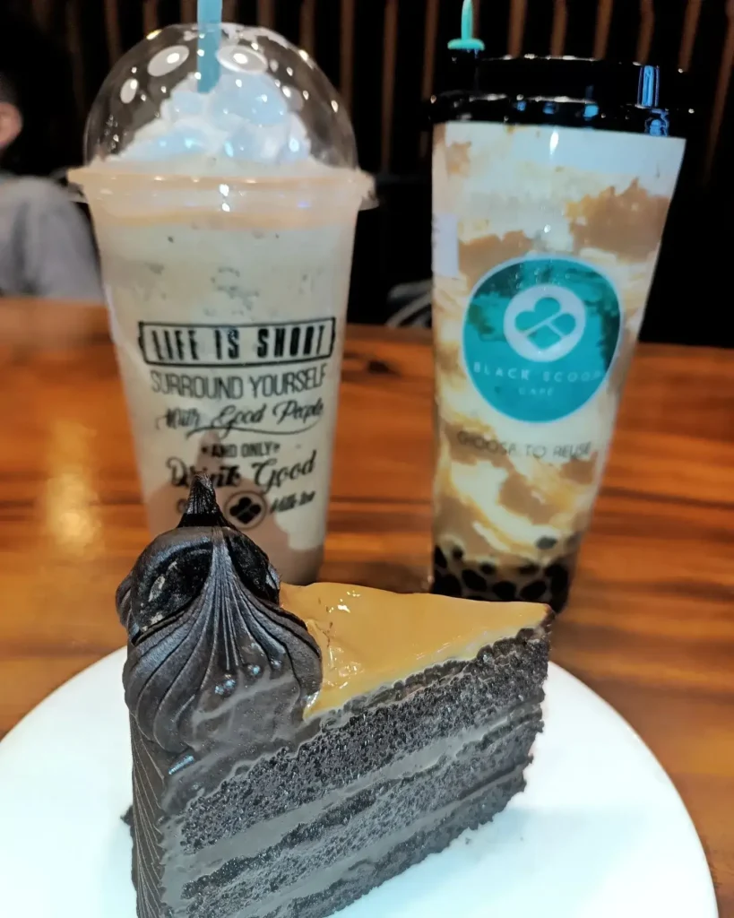 Cake in a plate with two cup of shakes, a menu of black scoop philippines resturant.